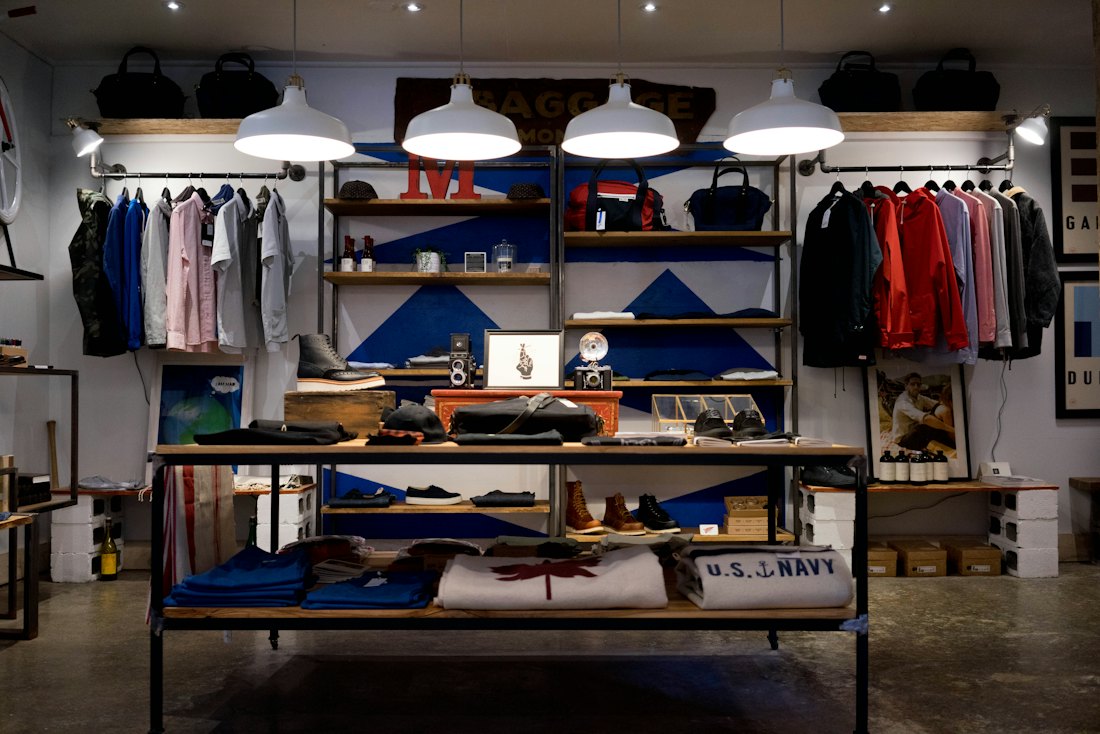 Interior de loja de roupas com araras e prateleiras